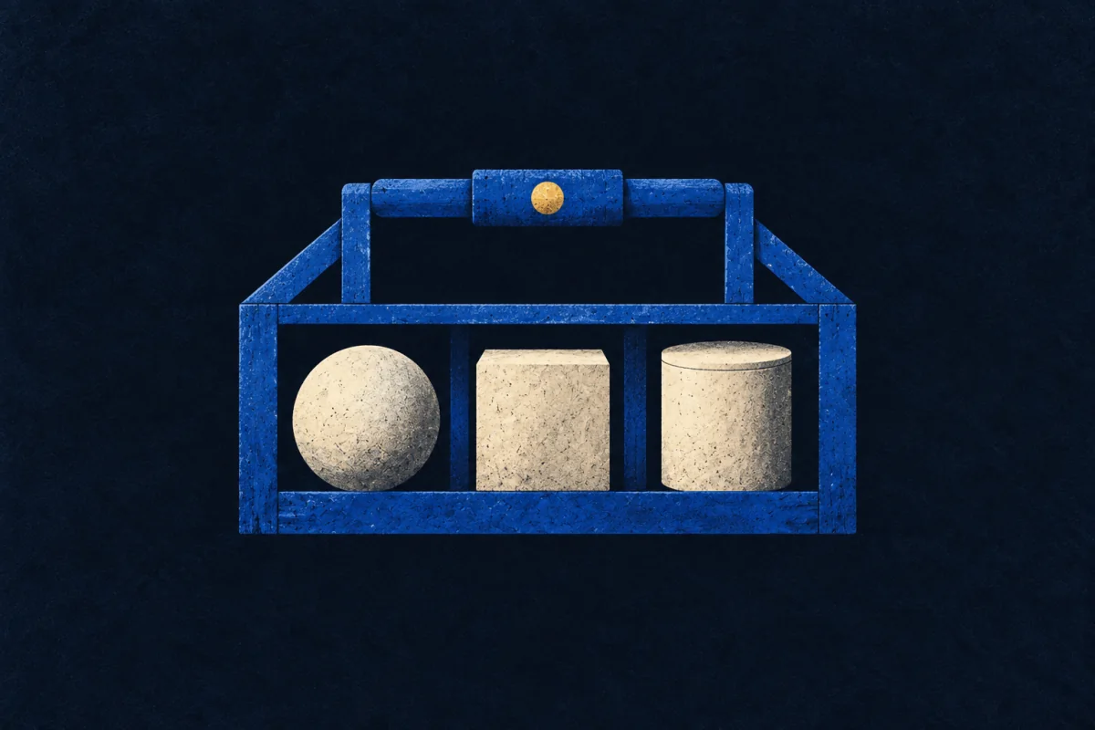 An open cobalt carrying frame holds an ivory sphere, cube, and cylinder in balanced compartments.